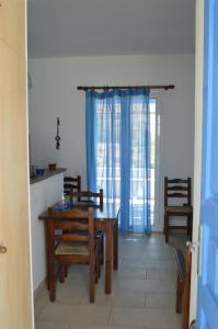 a dining room with a wooden table and chairs at Karyatides Houses in Kariá