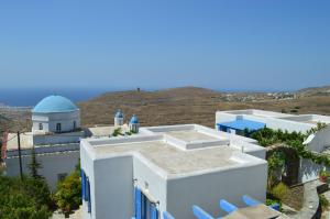 a view of a white building with a blue dome at Karyatides Houses in Kariá