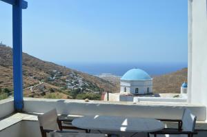 a table and chairs on a balcony with a building at Karyatides Houses in Kariá