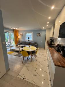 une cuisine et un salon avec une table et des chaises dans l'établissement Apartament Katarzyna, à Międzywodzie 21 autres photos