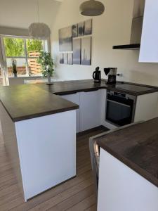a kitchen with white cabinets and black counter tops at Bøtø strand ferielejlighed 2 in Bøtø By +7 photos