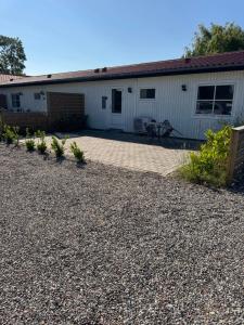 a patio in front of a white building at Bøtø strand ferielejlighed 2 in Marielyst