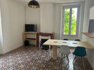 a room with a table and chairs and a fireplace at Appartement SUZANNE in Saint-Cyr-sur-Mer