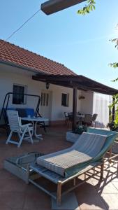 a patio with a hammock and a table and chairs at Traditional town house in Zastražišće +6 photos