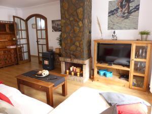 Una sala de estar con televisión y chimenea. en Ferienhaus Monte Azul, en Vélez-Málaga