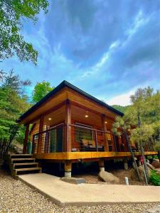 グレンデールにあるThe Hideaway Concealed Cabin East Zion & Bryceのポーチと階段が備わるログキャビン