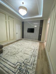 a large room with a large marble floor and a television at Апартамент Рахима Плаза2 in Shymkent