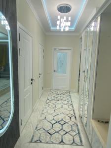 a hallway with a white door and a mirror at Апартамент Рахима Плаза2 in Shymkent +1 photo