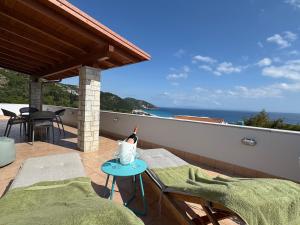 a balcony with a bottle of wine on a table at Augustus Hotel in Dhërmi +37 photos
