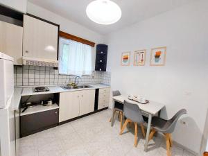 a kitchen with a sink and a table with chairs at Alexia Apartments & Studios in Kremasti