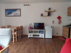 a living room with a tv and a table and a refrigerator at Casa Cornella cir226 in Pila
