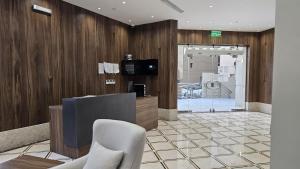 a lobby with a tv and a desk and chairs at Samama Almaqam Ajyad Hotel Makkah in Mecca