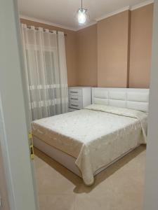 a bedroom with a white bed and a dresser at Sani Apartment in Golem