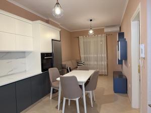 a kitchen and dining room with a table and chairs at Sani Apartment in Golem +4 photos