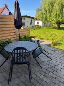 a table and chairs and an umbrella on a patio at Bøtø strand ferielejlighed 3 in Bøtø By