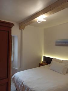 a bedroom with a white bed with a ceiling fan at Nuage climatisé in La Tremblade