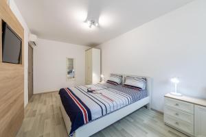 a white bedroom with a bed and a dresser at Apartment Caricia complex Carpe Diem Balchik in Balchik +35 photos