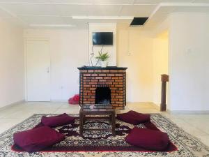 a living room with a brick fireplace and a table at Lavender Villas Nuwara Eliya in Nuwara Eliya