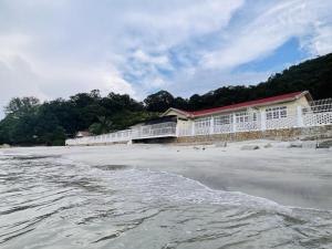 丹绒武雅Beach-Front Family Bungalow with Seaview Pool, KTV, Pool, PS5, Speaker System, BBQ & more!!的海边的一座建筑