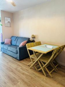 a living room with a blue couch and a table at La bohème Studio in La Grande-Motte