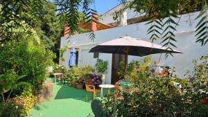 a patio with an umbrella and chairs and flowers at Terranova 
