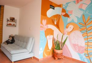 a living room with a couch and a colorful wall at Trip Monkey Origen in San Gil