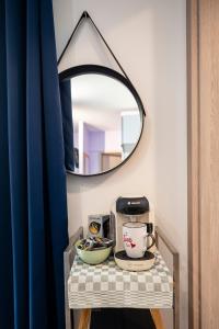 a table with a coffee maker and a mirror at Cozy compact studio France in Saint-Louis