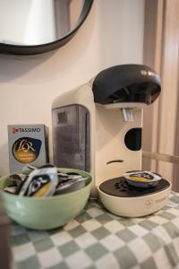 a coffee maker sitting on a table next to a bowl at Cozy compact studio France in Saint-Louis