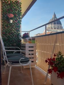 a balcony with a chair and a ivy covered wall at Saint Peter's Sunset View Luxury Apartment in Rome