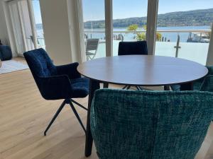 a table and chairs with a view of the water at Lakeside, awesome & romantic, with stylish design in Reichenau