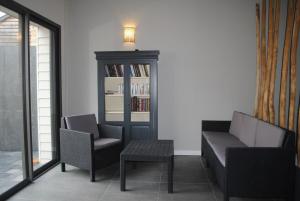 a porch with two chairs and a bench and a bookcase at Pause detente dans le golfe du morbihan in Auray