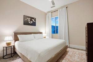Un dormitorio blanco con una cama grande y una ventana. en Unbeatable Location Golden Condo - Walk Everywhere, en Golden