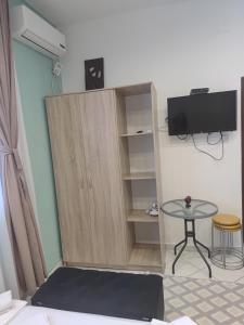 a cupboard with a tv and a table in a room at Becic Apartments in Ulcinj
