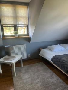 a bedroom with a bed and a chair and a window at Restauracja Dobre Smaki in Uniejow