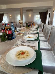 a long table with plates of pasta on it at Restauracja Dobre Smaki in Uniejow