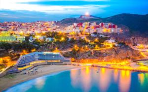 a city with a beach and buildings at night at Al HOCEIMA in Tirhanimîne