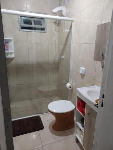 a bathroom with a shower and a toilet and a sink at Meu lar na praia in Jaguaruna +36 photos