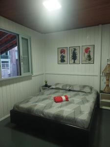 a bedroom with a bed with a red ribbon on it at Meu lar na praia in Jaguaruna +36 photos