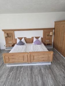 a bedroom with a large wooden bed with two pillows at Ferienwohnung Allgäu 134 in Wiggensbach