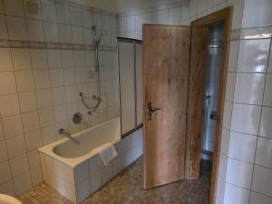 a bathroom with a bath tub and a mirror at Ferienwohnung Allgäu 134 in Wiggensbach +6 photos