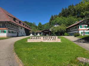 a sign in the grass in front of a building at Ferienwohnung Allgäu 134 in Wiggensbach