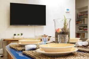 a table with plates and bowls and a tv at Il Castello delle dame - Il Maschio in Vigevano