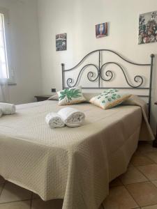a bedroom with a bed with two towels on it at Maison Linda in Santa Teresa Gallura