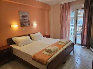 a bedroom with a bed with two towels on it at Philippos Hotel in Paralia Katerinis
