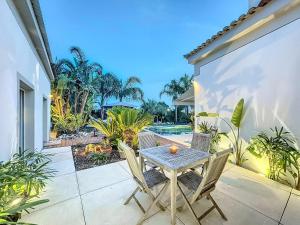 einen Tisch und Stühle auf der Terrasse eines Hauses in der Unterkunft Beautiful luxury villa in Antibes