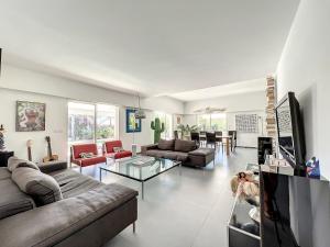 ein Wohnzimmer mit einer Couch und einem Glastisch in der Unterkunft Beautiful luxury villa in Antibes