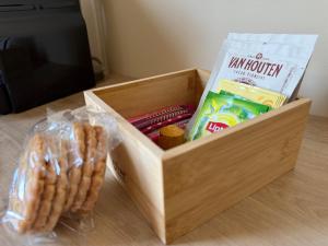 Una caja de madera con algo de comida y una bolsa de cacahuetes. en Suite du Spa 3 - Parking Privé Gratuit, en Reims 7 fotos más