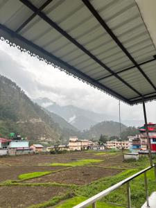 a view of a town with mountains in the background at Divine Ganga in Maneri
