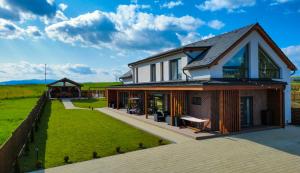 a house with a fence and a grass yard at NOVA House Apartments in Delniţa