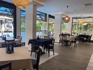a restaurant with tables and chairs and a pool at Апартамент Green Lines in Primorsko